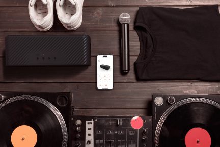 Pick-up-uri DJ, microfon, boxe, pantofi sport albi, smartphone pe masă de lemn, vedere de sus