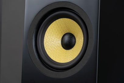 Gulvhøjttaler Davis Acoustics Courbet nr. 4 mat sort, nærbillede af en cirkulær højttalerenhed med en tekstureret gul membran