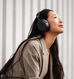 Asiatisk kvinde set fra siden med et sort og sølvfarvet hovedsæt på, langt sort hår, lukkede øjne og et fredeligt udtryk