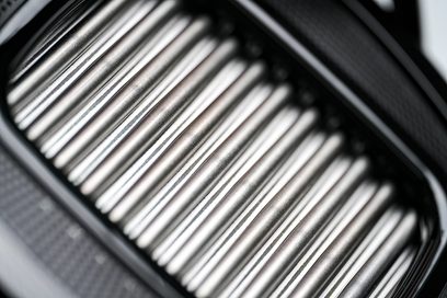 Sluchátka Hifiman Arya s otevřenou konstrukcí a kabelovým připojením, detailní záběr na stříbrný kovový gril složený z rovnoběžných válcových tyčí
