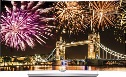 Farverige fyrværkerier eksploderer på den nattemørke himmel over det oplyste Tower Bridge i London