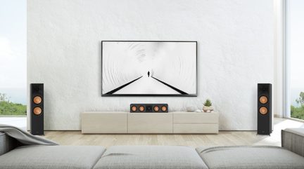 Moderne stue med grå sofa, beige TV-møbel, sorte højttalere, sort og hvid abstrakt maleri på hvid væg