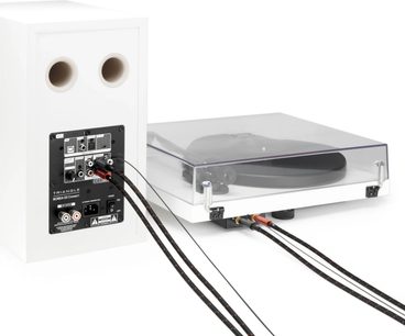 Czarny i czerwony pleciony stereofoniczny kabel RCA Triangle RED między białą kolumną a gramofonem