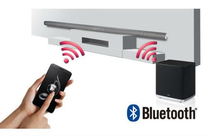 En hånd holder en smartphone, der styrer en sort lydenhed med Bluetooth-logo, som udsender røde bølger
