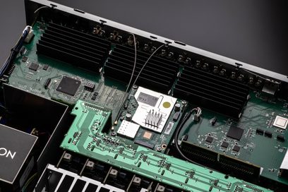 Vista interna di un amplificatore Denon AVC-X4800H argento che mostra i circuiti stampati verdi con componenti elettronici
