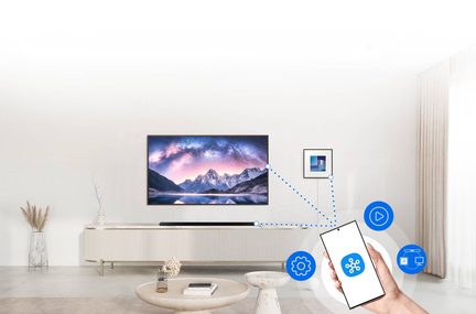 Væghængt fjernsyn, der viser et bjerglandskab, lavt møbel med dekorative genstande, smartphone i hånden, tilsluttede ikoner