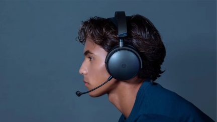 Black gaming headset with boom microphone worn in profile against a blue-gray background