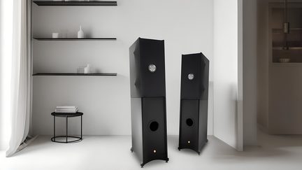Pár černých hi-fi sloupových reproduktorů s hranatým designem, pohled zepředu, v minimalistickém interiéru