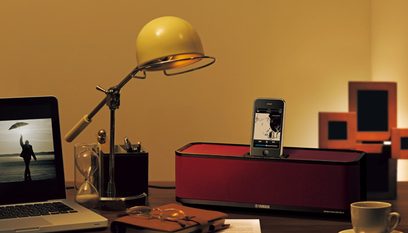 Yamaha PDX-31 rød dockingstation, skrivebordslampe, bærbar computer, iPhone og tilbehør på et træskrivebord