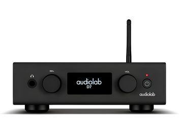 Vista frontal de um DAC Audiolab D7 preto em metal, caixa retangular apoiada em pés com visor central retroiluminado, dois botões redondos, entrada para fones de ouvido, botão de alimentação com LED e antena vertical