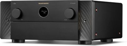 Matinis juodas aliumininis Marantz AV 20 namų kino stiprintuvas, trijų ketvirčių priekinis vaizdas, minimalistinis fasadas su apšviestu centriniu apvaliu ekranu, dvi simetriškos didelės rankenėlės, tekstūriniai šoniniai skydeliai, integruota ausinių jungtis ir maitinimo mygtukas