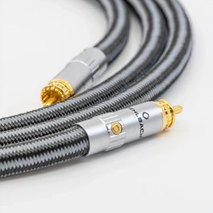 Nærbillede i let diagonal vinkel af Oehlbach Sub Xtreme 4,4m sort-grå kabel med flettet nylonkappe, udstyret med cylindriske RCA-stik i sølvfarvet metal med riflede ringe og guldbelagte pins