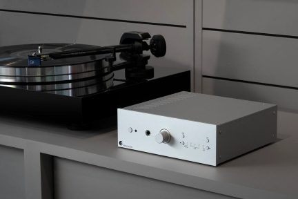 Phono-förförstärkare Pro-Ject Stereo Box DS3 silver med central knapp och reglage på fronten bredvid en vinylspelare