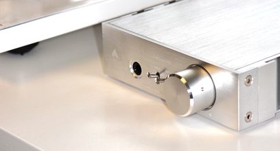 Audeze Deckard hovedtelefon-forstærker i børstet aluminium, tæt forfra-billede af hovedtelefonstikket og lydstyrkeknappen