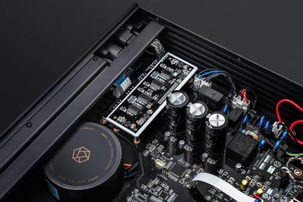 Inuti en elektronisk apparat, svart metallchassi, svarta aluminiumkondensatorer med silverfärgade toppar, svart cylindriskt hölje