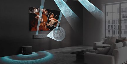 Barra sonora nera con finitura in metallo spazzolato fissata sotto un televisore, subwoofer cubico nero opaco a terra, vista prospettica di un salotto moderno con rappresentazioni grafiche blu delle onde sonore
