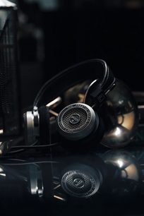 Offener HiFi-Kopfhörer Grado SR325x, Nahaufnahme der linken Seite, runde schwarze Ohrmuscheln mit silbernem Metallgitter