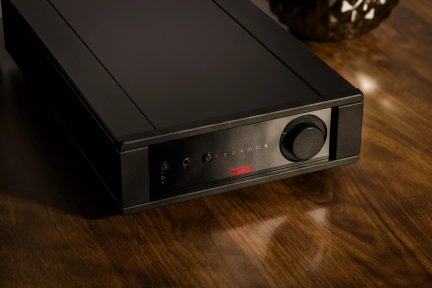 Black rectangular case with a front panel featuring a circular button, indicator lights, ports, and a red logo