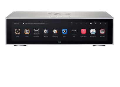 Reproductor de audio en red RS151 plateado con panel frontal rectangular, pantalla táctil negra que muestra íconos coloridos, patas circulares visibles