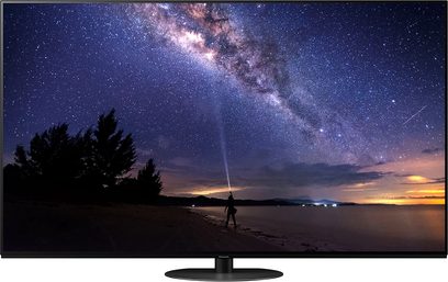 Panasonic TX-65JZ1000E-fladskærm, der viser et natligt stjernelandskab med en person ved bredden af en sø, set forfra