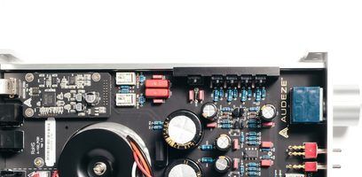Elektronisk printplade med komponenter, stik og ledningsføring, tæt på indblik i indersiden af et audioapparat