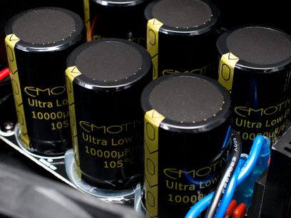 Sorte cylindriske elektrolytiske kondensatorer "Emotiva Ultra Low ESR 10000μF 105°C" med guldstriber, tæt ovenfra-billede