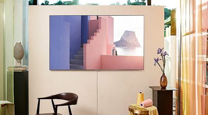 Abstraktní malba s barevnými geometrickými tvary v růžové, modré a fialové barvě, zavěšená na stěně moderního interiéru