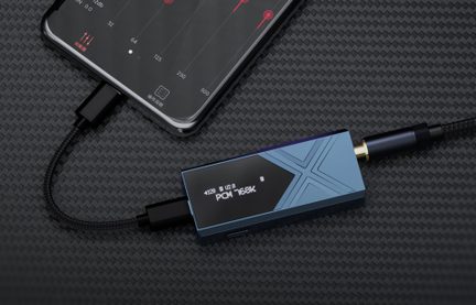 Kleine rechthoekige blauwe audiobehuizing van mat aluminium met een gegraveerd X-motief, zwart OLED-scherm met de tekst "PCM 768K", USB-C- en jackpoorten aan de uiteinden, bovenaanzicht