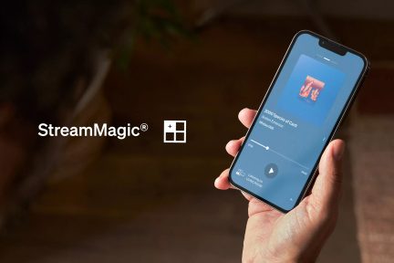 Aplikacja StreamMagic na smartfonie trzymanym w dłoni, interfejs odtwarzania audio i logo Windows