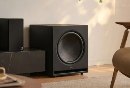 Önden görünümde siyah Elipson subwoofer, modern bir oturma odasında büyük dairesel hoparlörlü