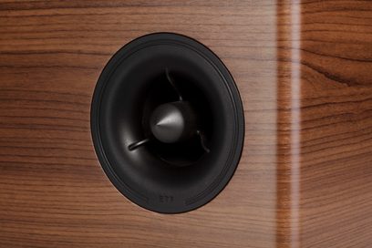 Centrální reproduktor Polk Audio R400 v ořechovém provedení, pohled zepředu, černý kruhový kryt uprostřed, tmavé dřevěné provedení
