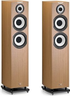 Enceintes colonnes en bois clair, face avant avec 4 haut-parleurs circulaires noirs alignés verticalement, sur socle noir