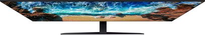 Samsung UE82NU8005-fjernsyn, der viser en sandstrand og en urolig hav under en skyfyldt, blå himmel med levende og kontrastrige farver
