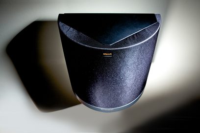 Klipsch RS-42 MkII sort højttaler, set fra en let nedadgående bagfra tre-kvarters vinkel, oplyst af et blåt lys