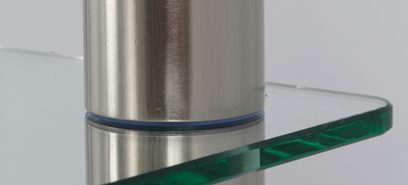 Detalje af en cylindrisk metalfod med børstet overflade fra et Norstone Epur 3 AV møbel med en translucent grøn glashylde