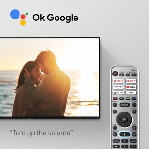 Par på stranden i solnedgangen med "Ok Google" TV-fjernbetjening overlagt