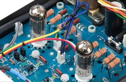 Vista interior de un preamplificador de auriculares STAX SRM-500T que muestra circuitos impresos, componentes electrónicos, tubos de vacío y cableado