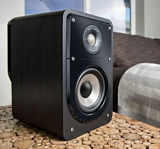 Polk Audio S15e sort bogreolhøjttaler, set forfra, stående på en bunke lyse træskiver