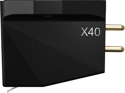 Mattschwarze Ortofon MC X40 Tonabnehmerzelle aus Kunststoff, Seitenansicht von links, eckiges Gehäuse mit X40-Schriftzug, zwei vergoldete Anschlussstifte auf der Rückseite und feine Metallnadel an der Unterseite sichtbar