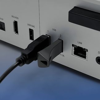 Silbernes Aluminium-Rückpanel eines elektronischen Geräts, schräge Nahaufnahme, mit ausgerichteten HDMI-, USB- und LAN-Anschlüssen, eingestecktem schwarzen USB-Kabel und schwarzem USB-Stick