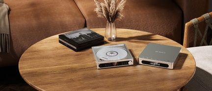 FiiO Hi-Fi CD-Player in Silber mit transparentem Deckel und passendem Audiogehäuse auf Holztisch