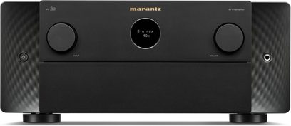 Marantz AV 20 namų kino stiprintuvas-priešstiprintuvas, juodos spalvos, iš šlifuoto metalo, matomas iš priekio, su dviem dideliais apvaliais ratukais, išdėstytais abipus centrinio apvalaus ekrano, šonai su banguotu raštu, kairėje – maitinimo mygtukas, dešinėje – ausinių lizdas