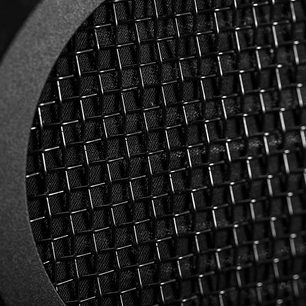 Close-up of a black metal grill with a fine, uniform rounded mesh pattern, viewed perpendicularly to the surface
