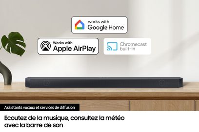 Samsung HW-Q710D sort soundbar, set forfra, placeret på et lyst trækabinet, med kompatibilitetslogoer