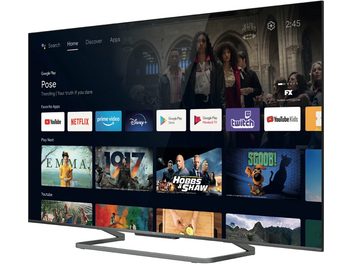 TCL 75C727-fjernsyn, der viser Google TV-grænsefladen med miniaturebilleder af film, tv-serier og apps på en sort baggrund