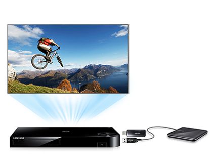 Cyklist springer over bjerge på cykel, DVD-afspiller og ekstern harddisk på hvid baggrund i bunden af billedet