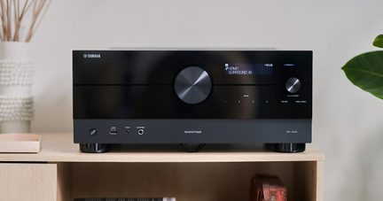 Ampli home cinéma Yamaha Aventage RX‑A4A noir, façade avant avec grand bouton central, posé sur étagère en bois