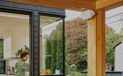 Glazen ramen in een houten kozijn, gezien van binnen een huis naar buiten op een tuin met gekleurde bomen en struiken in de herfst