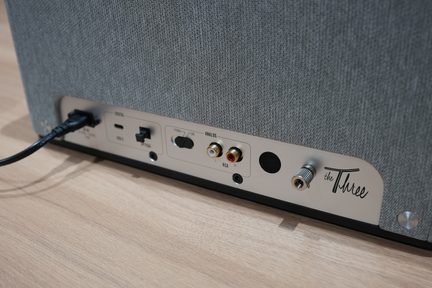 Metallist ristkülikukujuline tagapaneel punaste ja valgete RCA-pistikute, USB-pordi, optilise sisendi, lüliti ja pöördnupuga