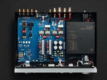 Sølvfarget Rose RA280 hi-fi stereoforsterker, innvendig sett ovenfra med blått kretskort og store kondensatorer